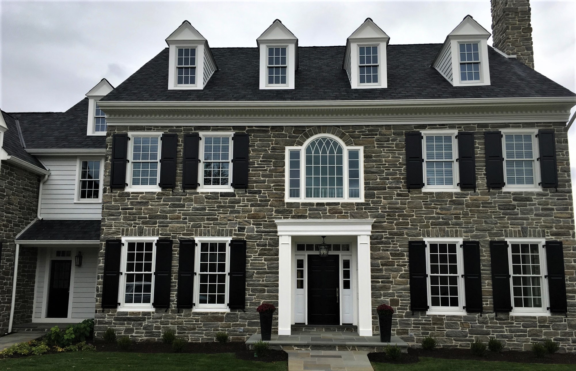 Exterior of a stone home with new windows