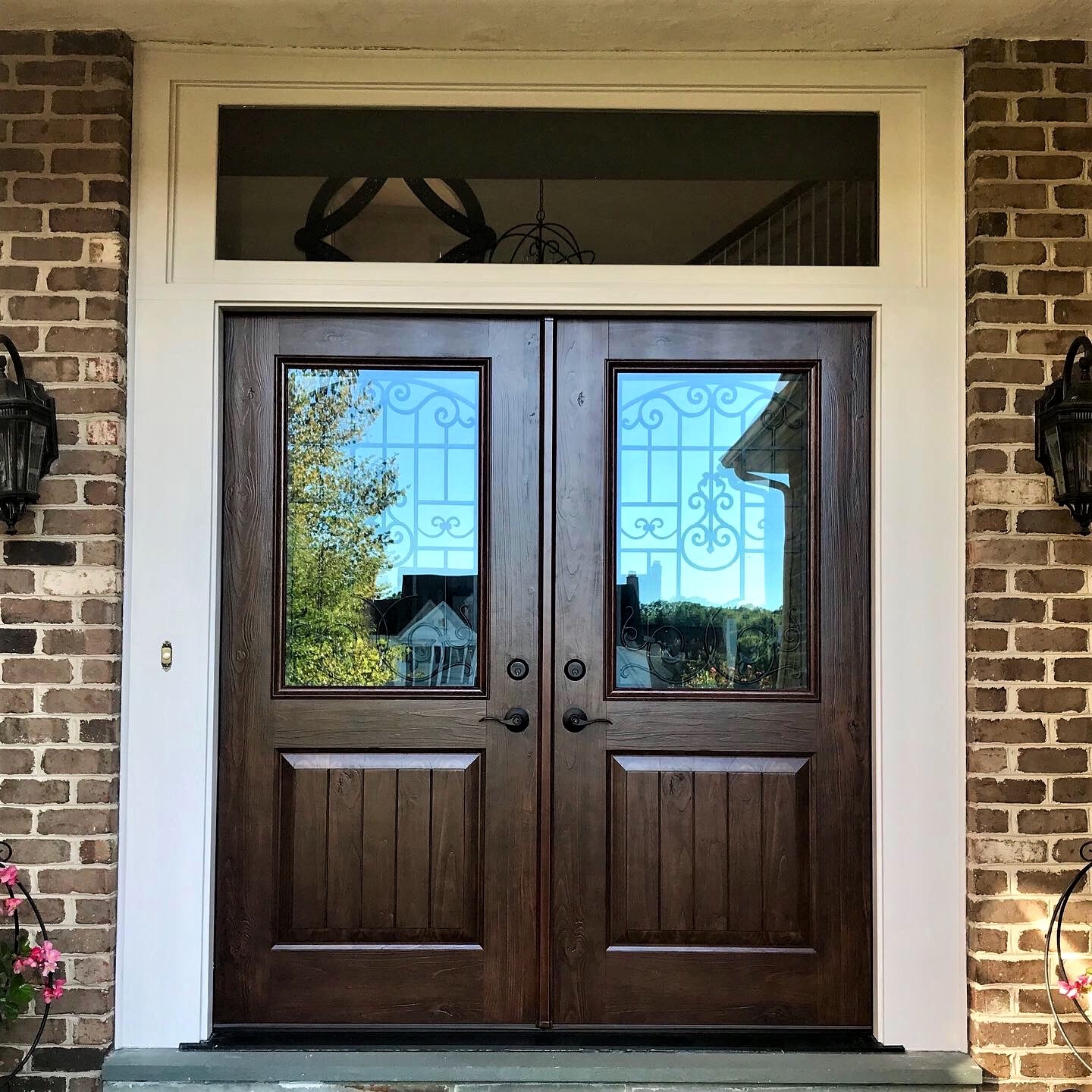A home with brown double front doors with windows
