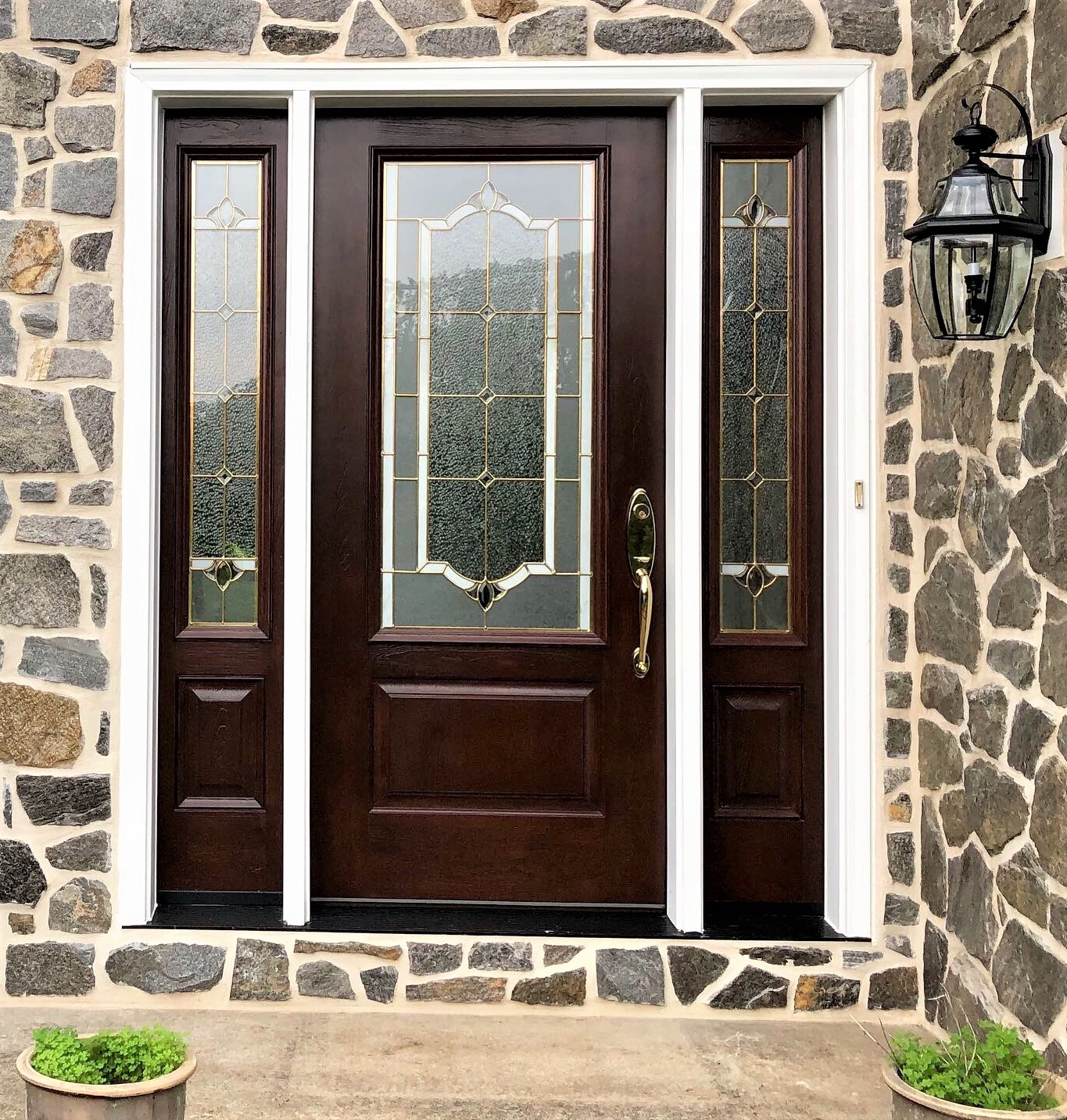 Exterior of a home with brown front door and stone siding