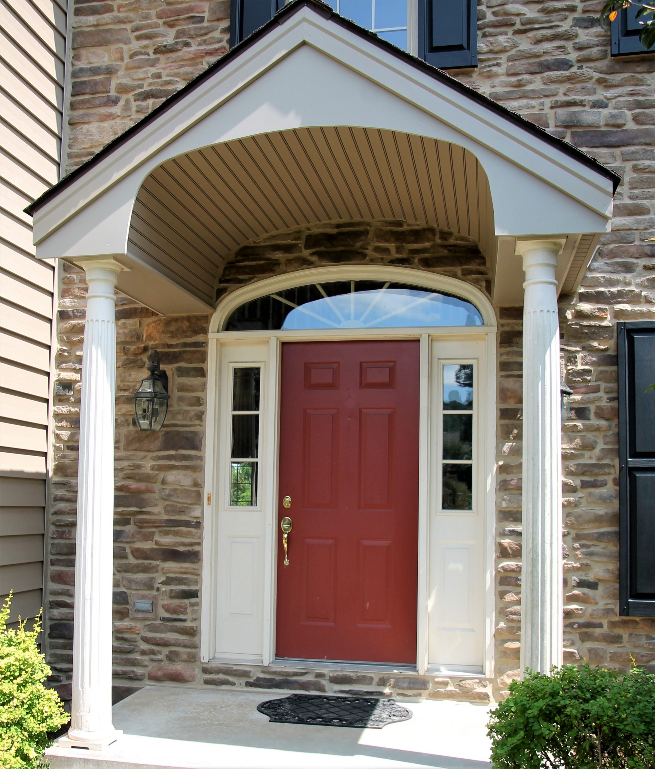 Exterior of home with a red front door with awning