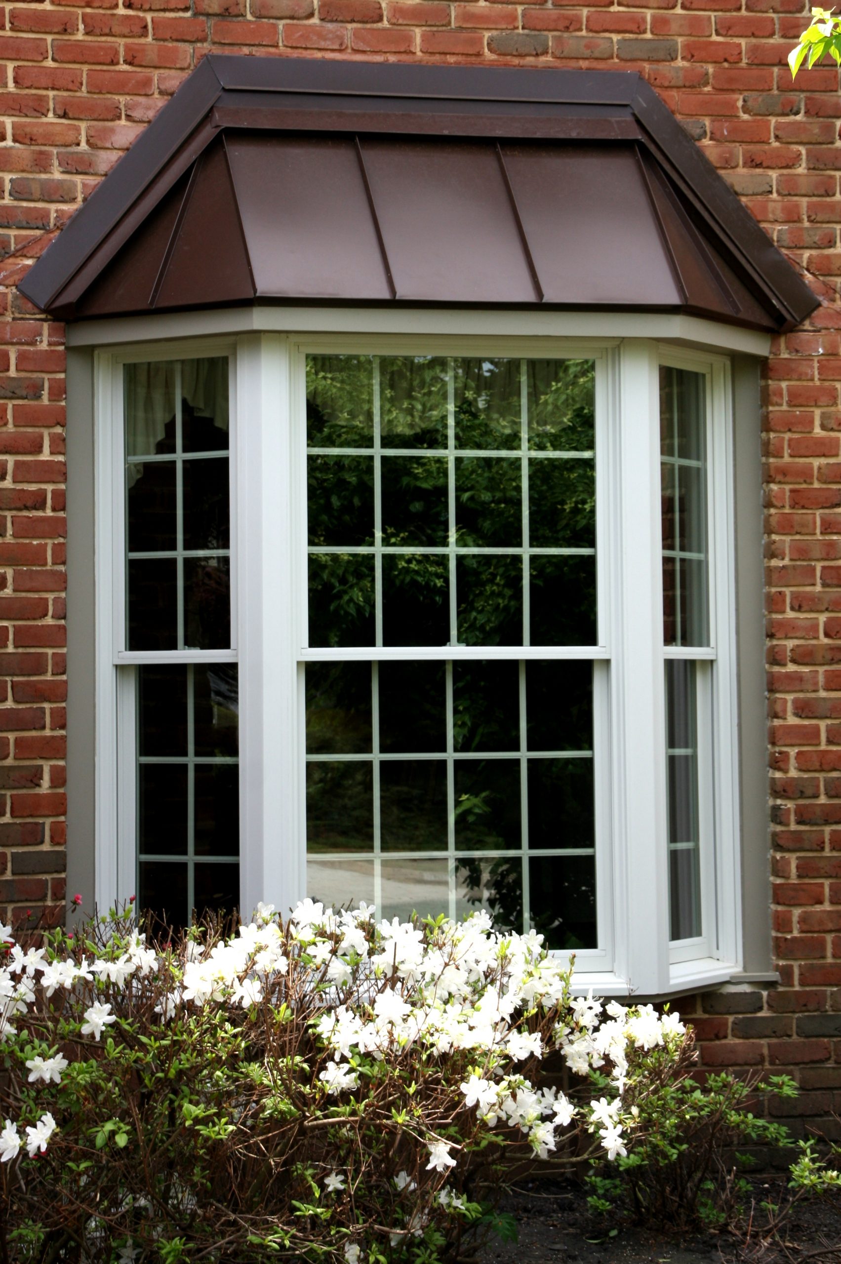 A white bay window with copper roof