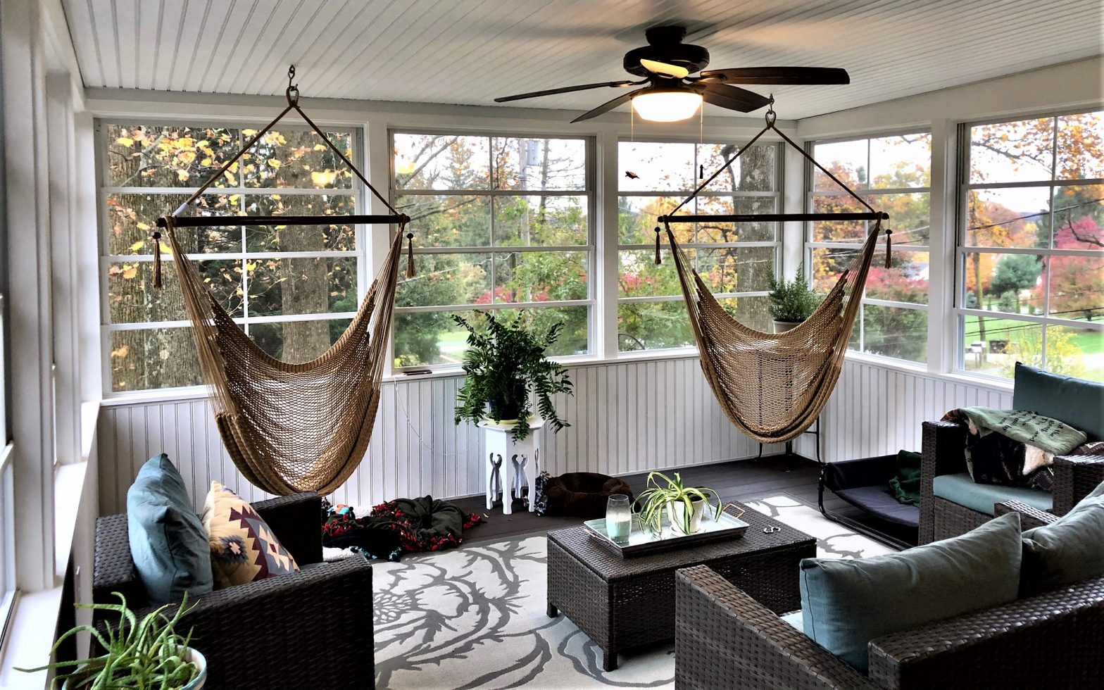 Interior of a three season room with two hanging hammock chairs