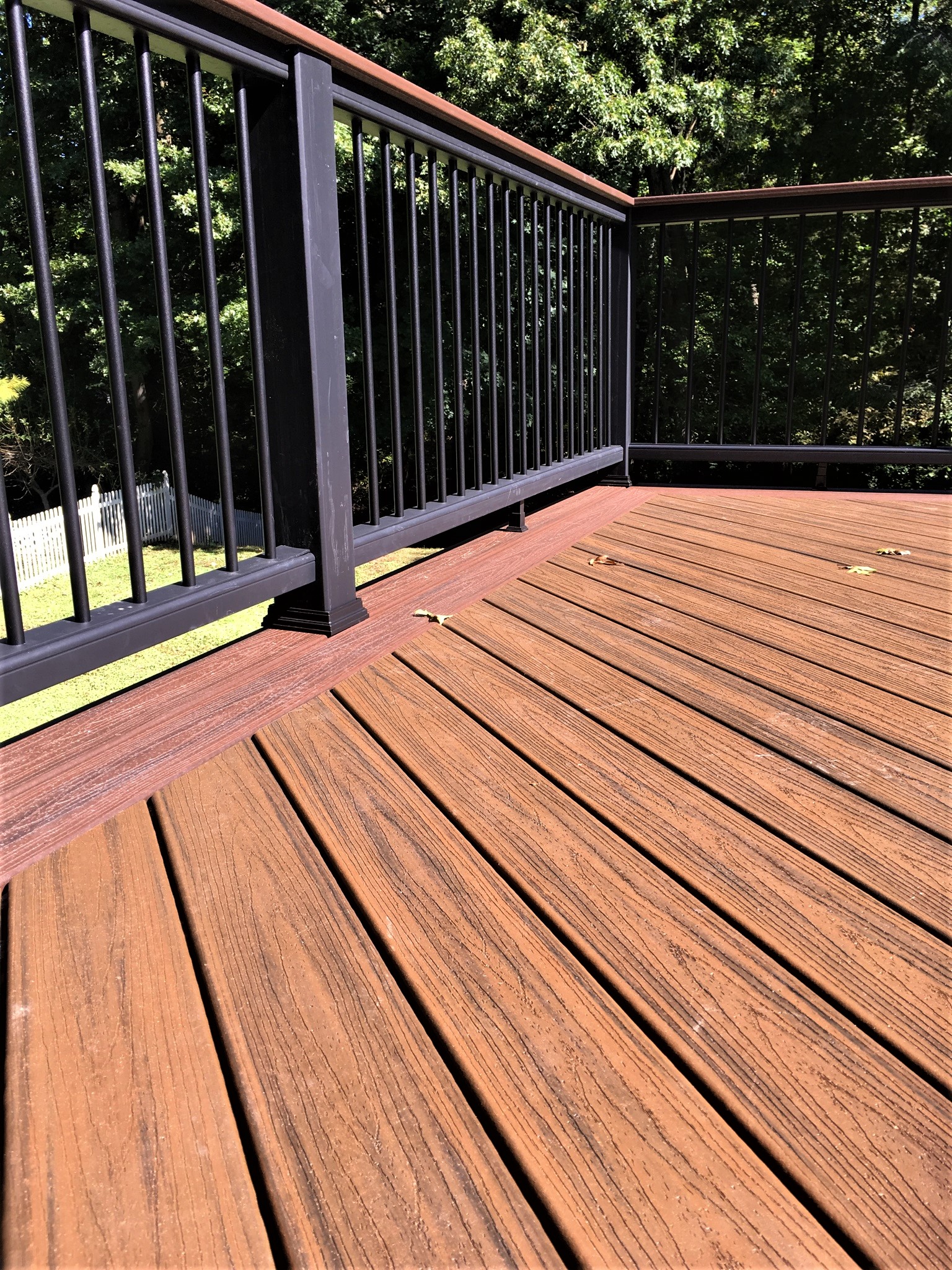 Closeup of a brown composite wood deck with black railing
