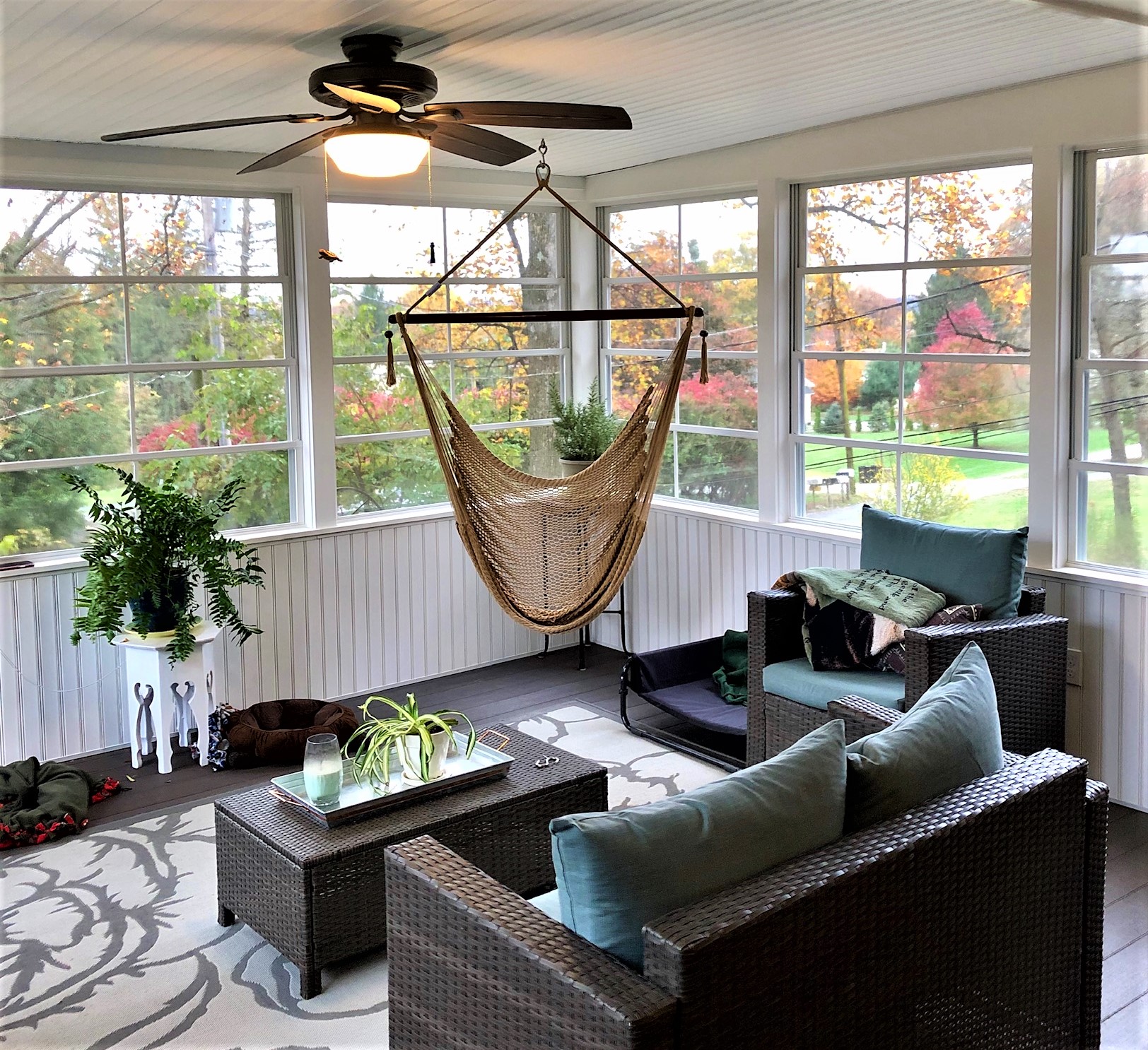 Sun room with a hammock, fan, and wicker furniture