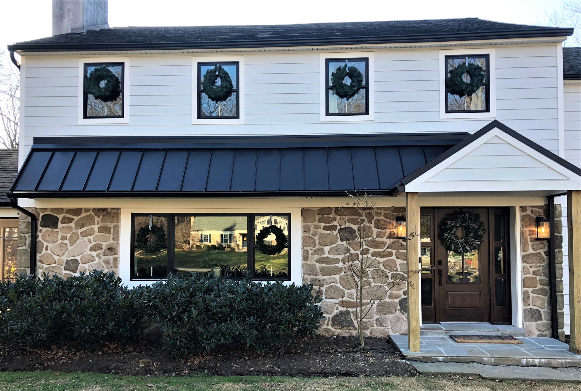 Front of a home with wreaths in the windows