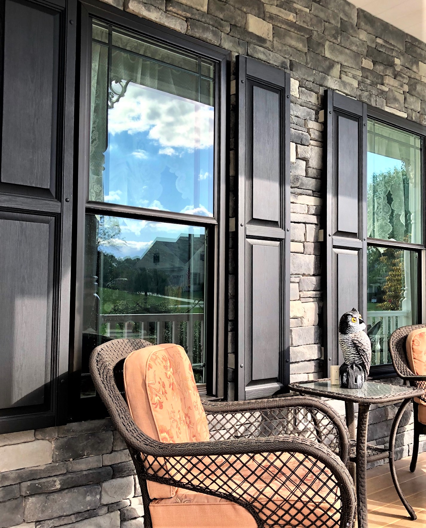 New windows with black shutters against a stone exterior