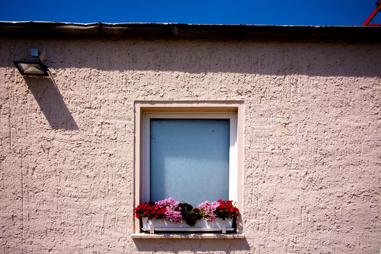 Window with flowers on a stucco house