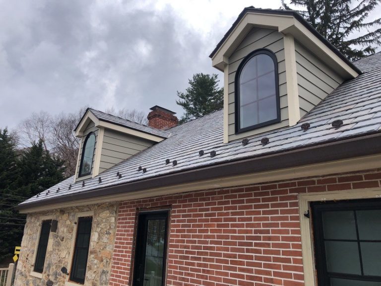 New DaVinci synthetic slate roofing installed on a residential home with half stone siding and half brick siding.